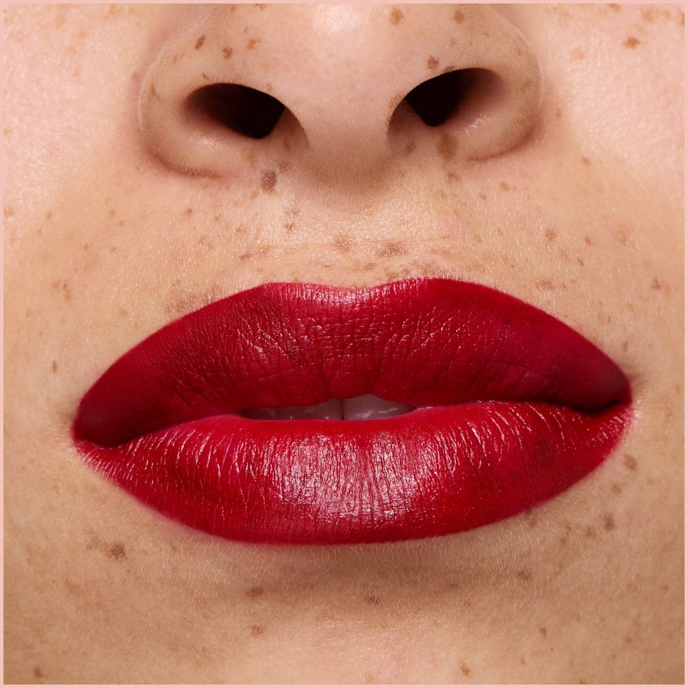 Nahaufnahme von Lippen, die mit rotem Lippenstift geschminkt sind.
