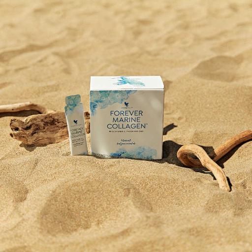 Produktverpackung und Einzelbeutel auf Sand. Aufschrift: Forever Marine Collagen. Einzelbeutel mit Produktname. Hintergrund: Sand und Treibholz.
