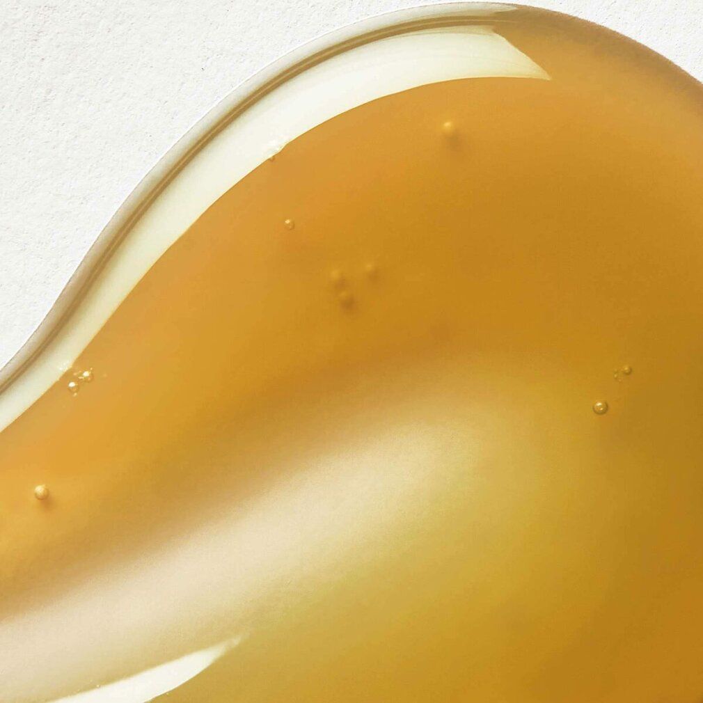 Gelartige Substanz in Goldgelb. Auf hellem Untergrund. Textur mit kleinen Bläschen.