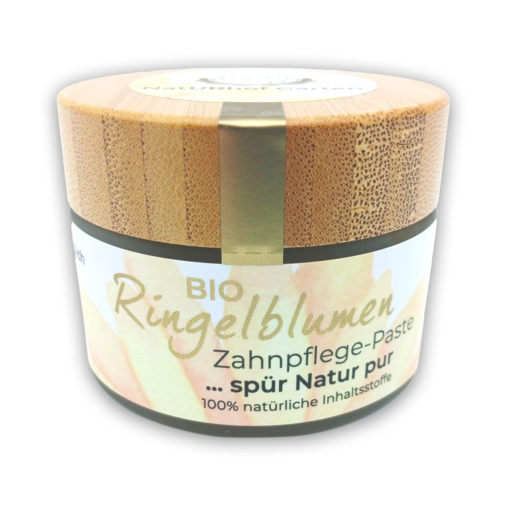 Zahncreme-Behälter mit Holzdeckel. Aufschrift: BIO Ringelblumen Zahnpflege-Paste. 100% natürliche Inhaltsstoffe.