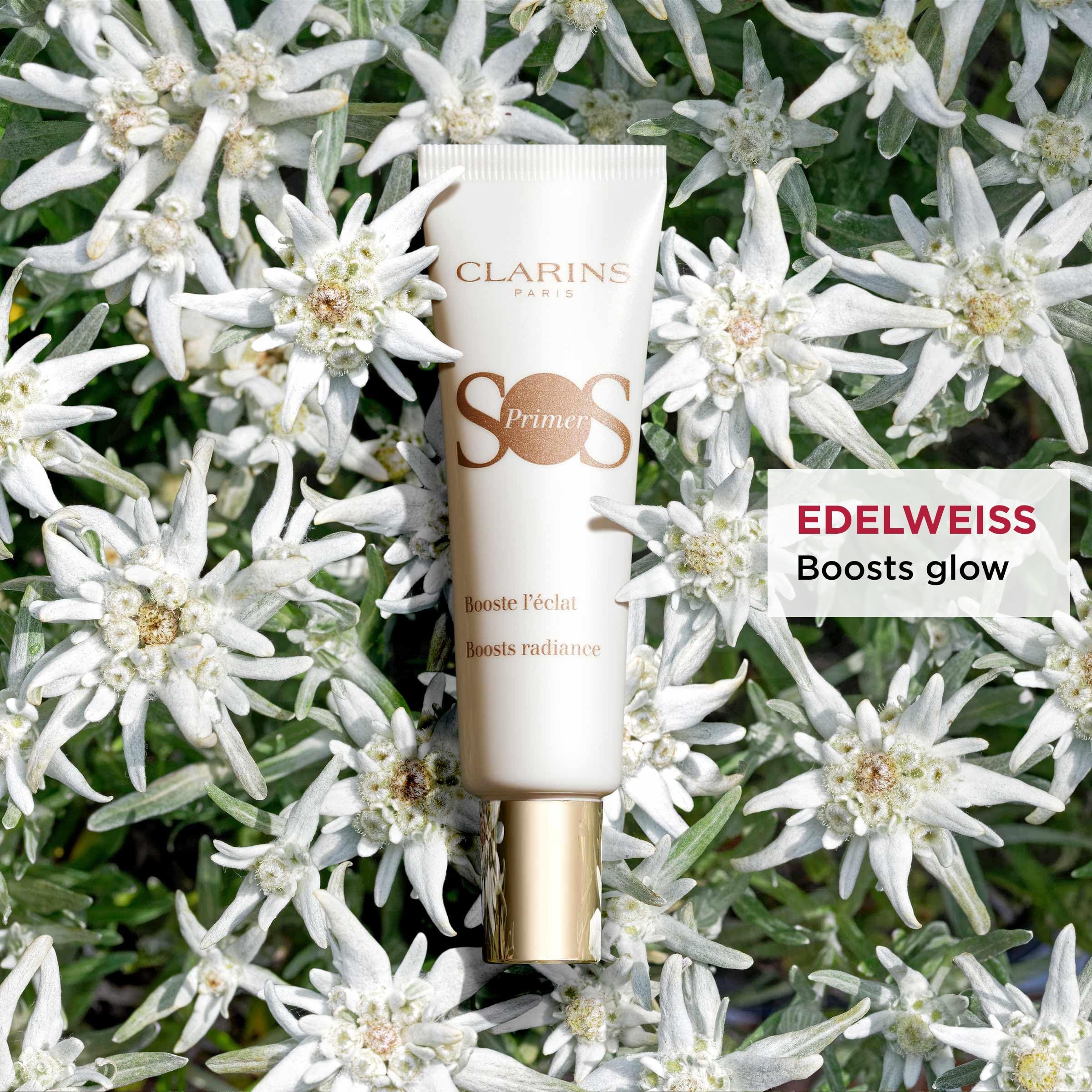 CLARINS SOS Primer Tube inmitten von Edelweißblüten. Boosts glow.