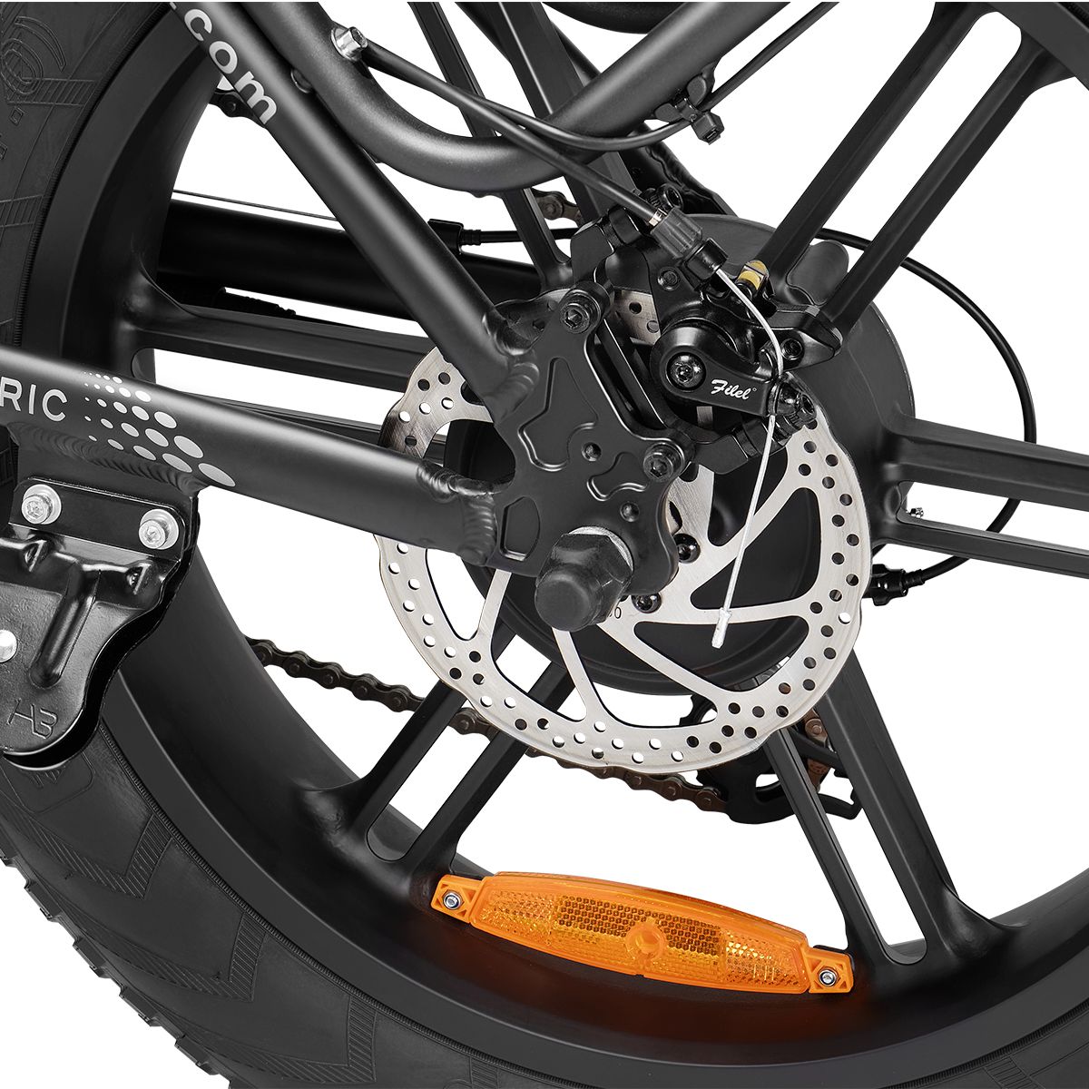 Nahaufnahme des Hinterrads eines E-Bikes. Scheibenbremse, Reflektor und Reifen sind sichtbar. Schwarze Felge.