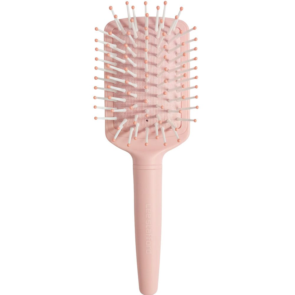 Eine rechteckige, hellrosa Haarbürste mit weiß-rosa Borsten und einem kurzen Griff.