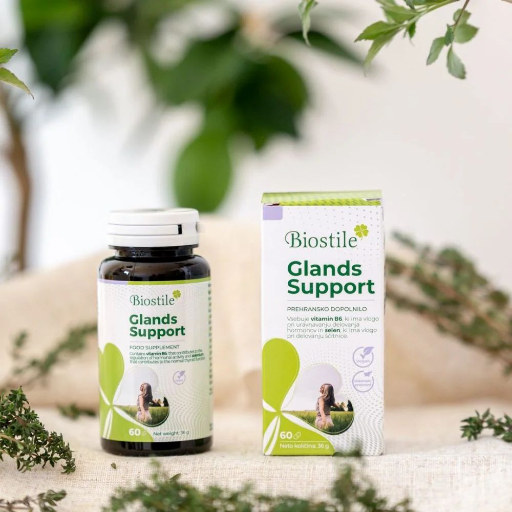 Produktverpackung und Flasche mit Aufschrift: Biostile Glands Support. Grün-weißes Design. 60 Kapseln. Auf einem Tisch.