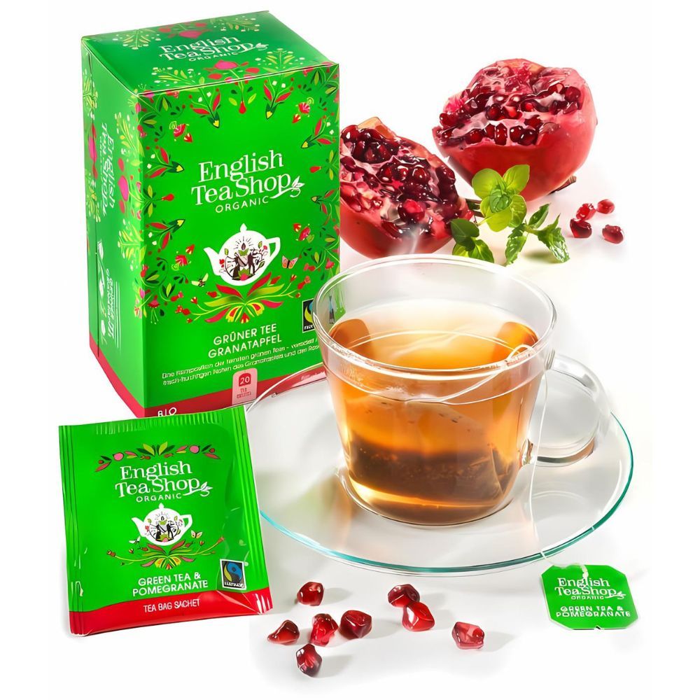 Glas Tee mit Teebeutel, Granatapfel und Tee-Box. 'English Tea Shop Organic' Box und Teebeutel.