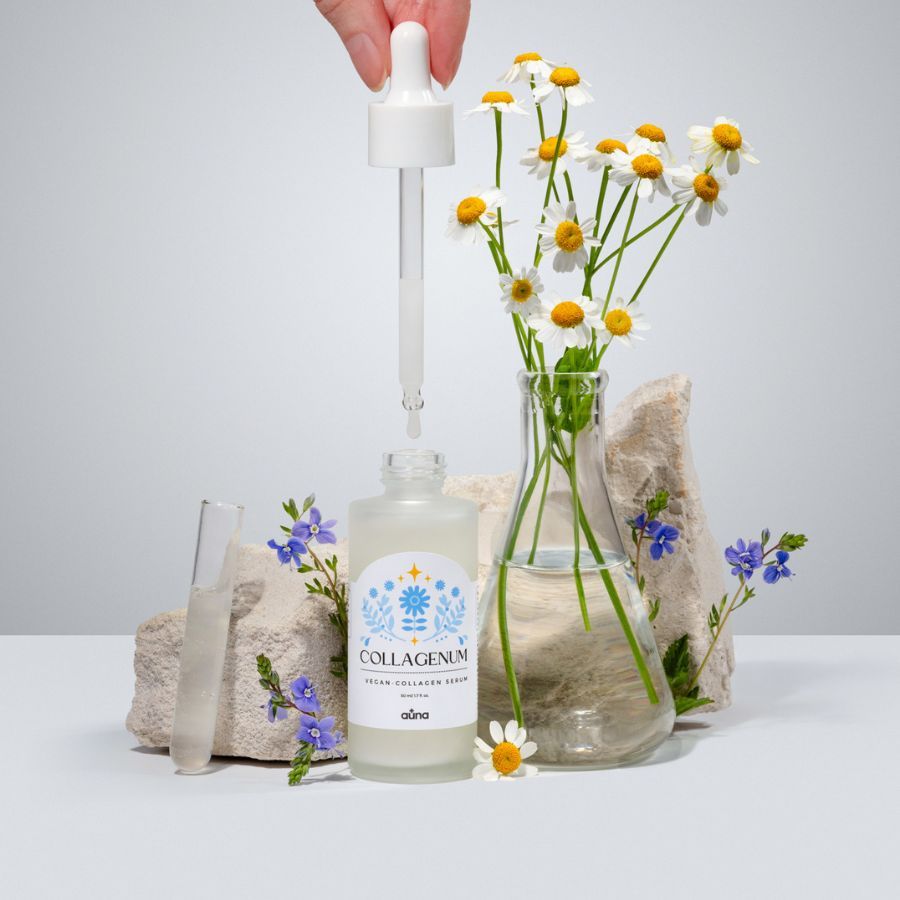 Auna Vegan Serum mit Pipette. Flasche vor Blumen und Steinen. Etikett mit "COLLAGENUM" und "vegan collagen serum".