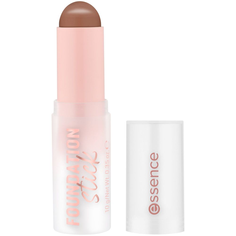 Essence Foundation Stick mit geöffneter Kappe. Produkt in cremefarbener Farbe. Rosa-weiße Verpackung mit Produktnamen und Logo.