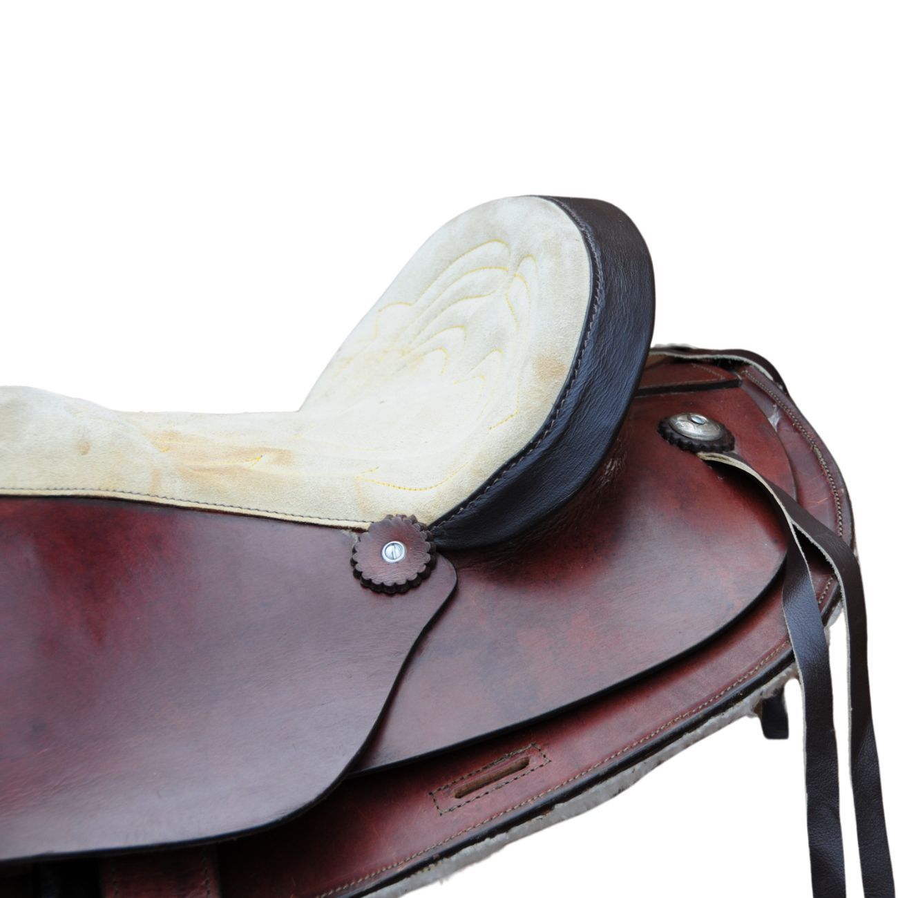 Brauner Sattel mit beigem Sitz und schwarzen Details. Leder, Metallbeschläge und Riemen sind sichtbar.