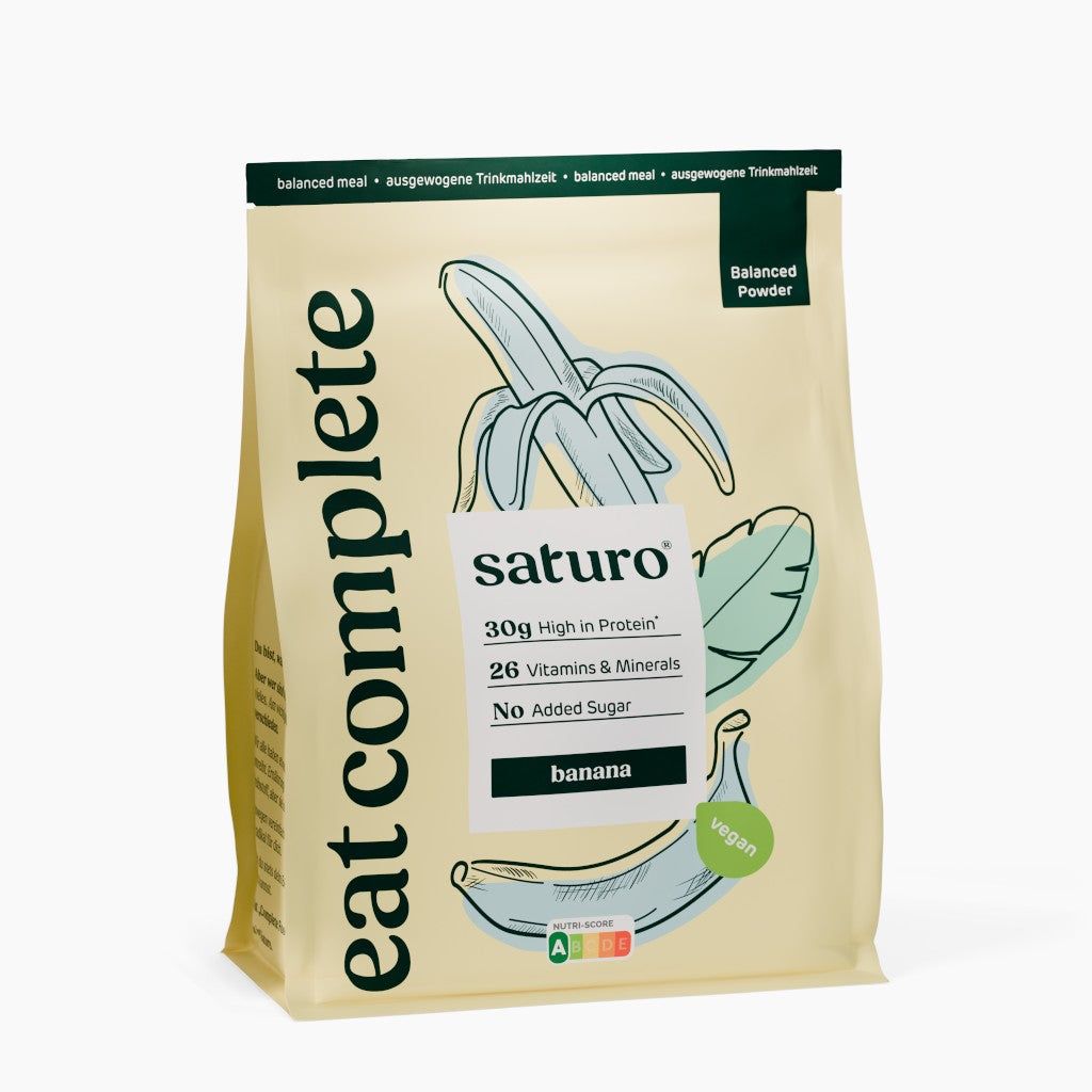 Beutel mit Bananen-Motiv. Aufschrift: saturo, 30g High in Protein, 26 Vitamins & Minerals, No Added Sugar, banana, vegan. Text: eat complete.