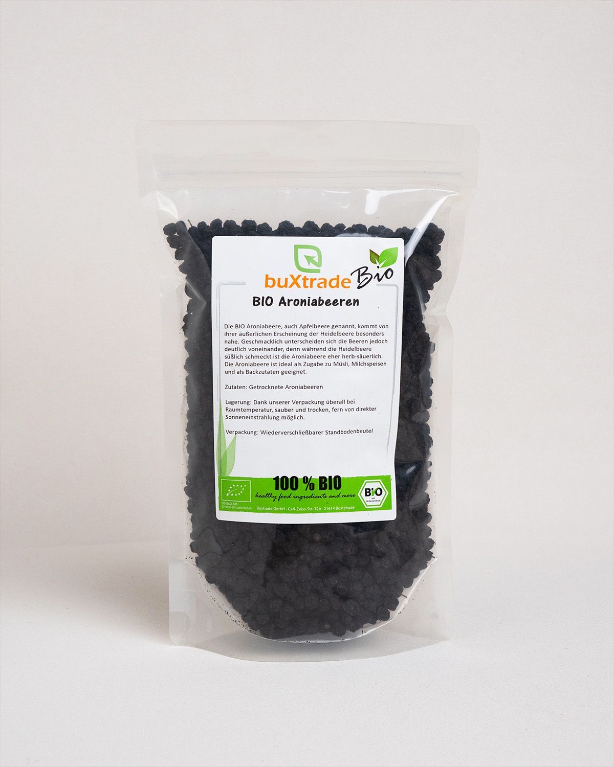 Transparente Verpackung mit buXtrade Bio Aroniabeeren. Aufdruck: 100% BIO. Grün-weißes Logo.