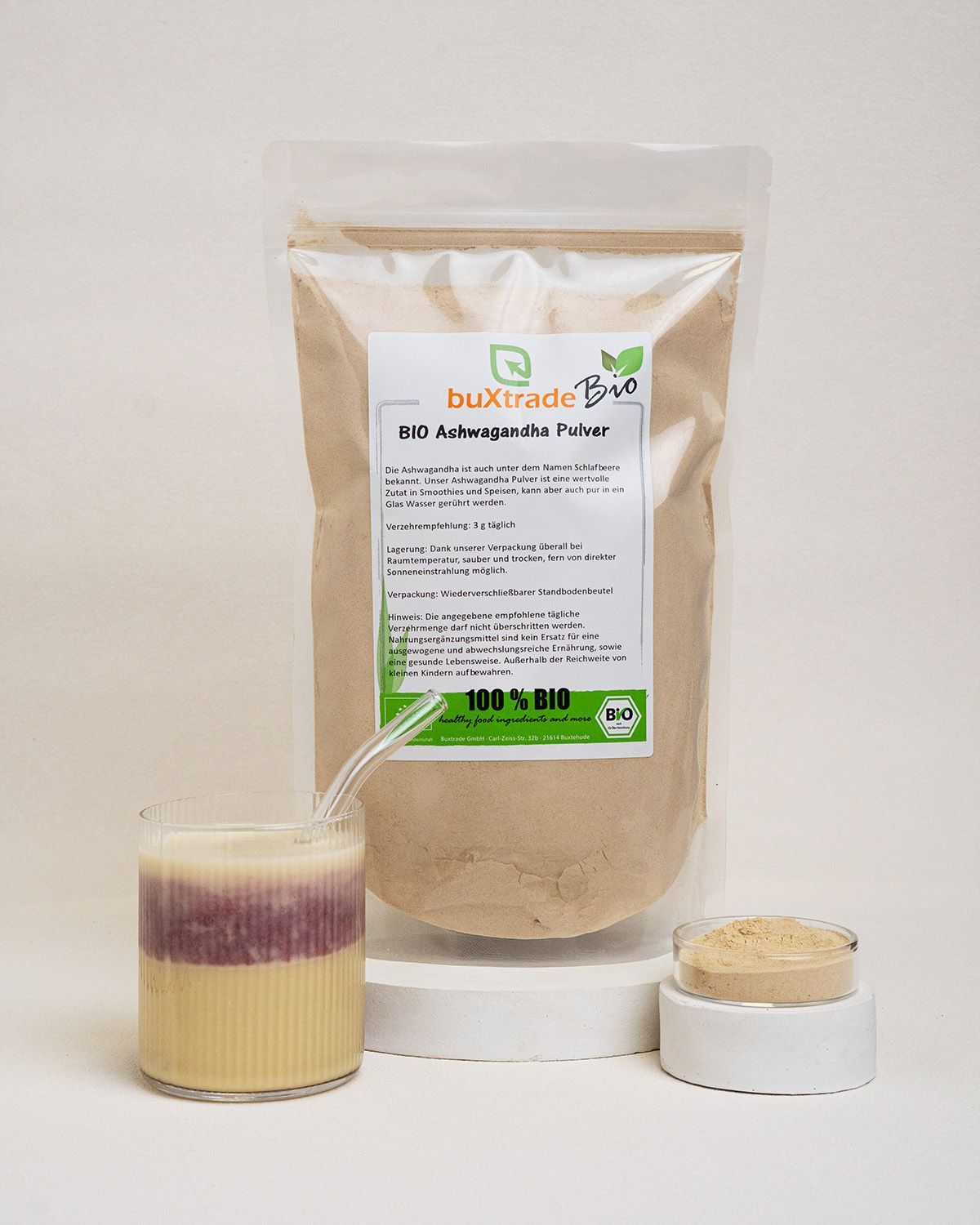 Beutel, Glas mit Flüssigkeit, Schale mit Pulver. 'buXtrade Bio Ashwagandha Pulver'.