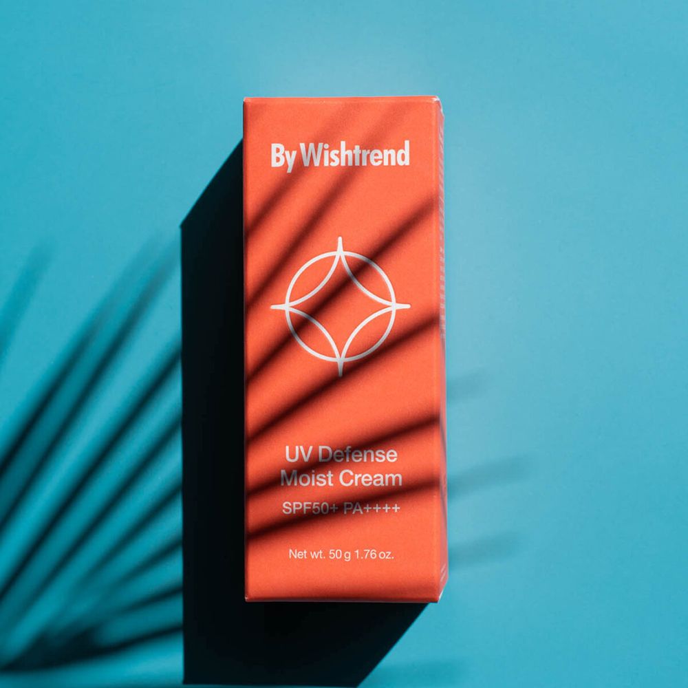 Orangefarbene Verpackung mit Schatten von Blättern. Aufschrift: UV Defense Moist Cream SPF50+ PA++++. Marke: By Wishtrend. Inhalt: 50 g 1.76 oz.