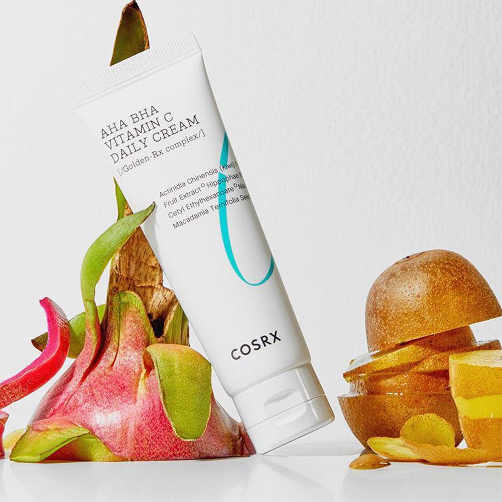 COSRX AHA BHA Vitamin C Daily Cream Tube umgeben von Drachenfrucht und Kiwi-Scheiben.