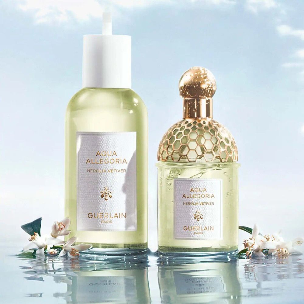 Zwei Parfumflakons, einer mit Sprühkopf, einer mit goldfarbenem Verschluss. Etiketten mit Text: Aqua Allegoria Nerolia Vetiver, Guerlain.