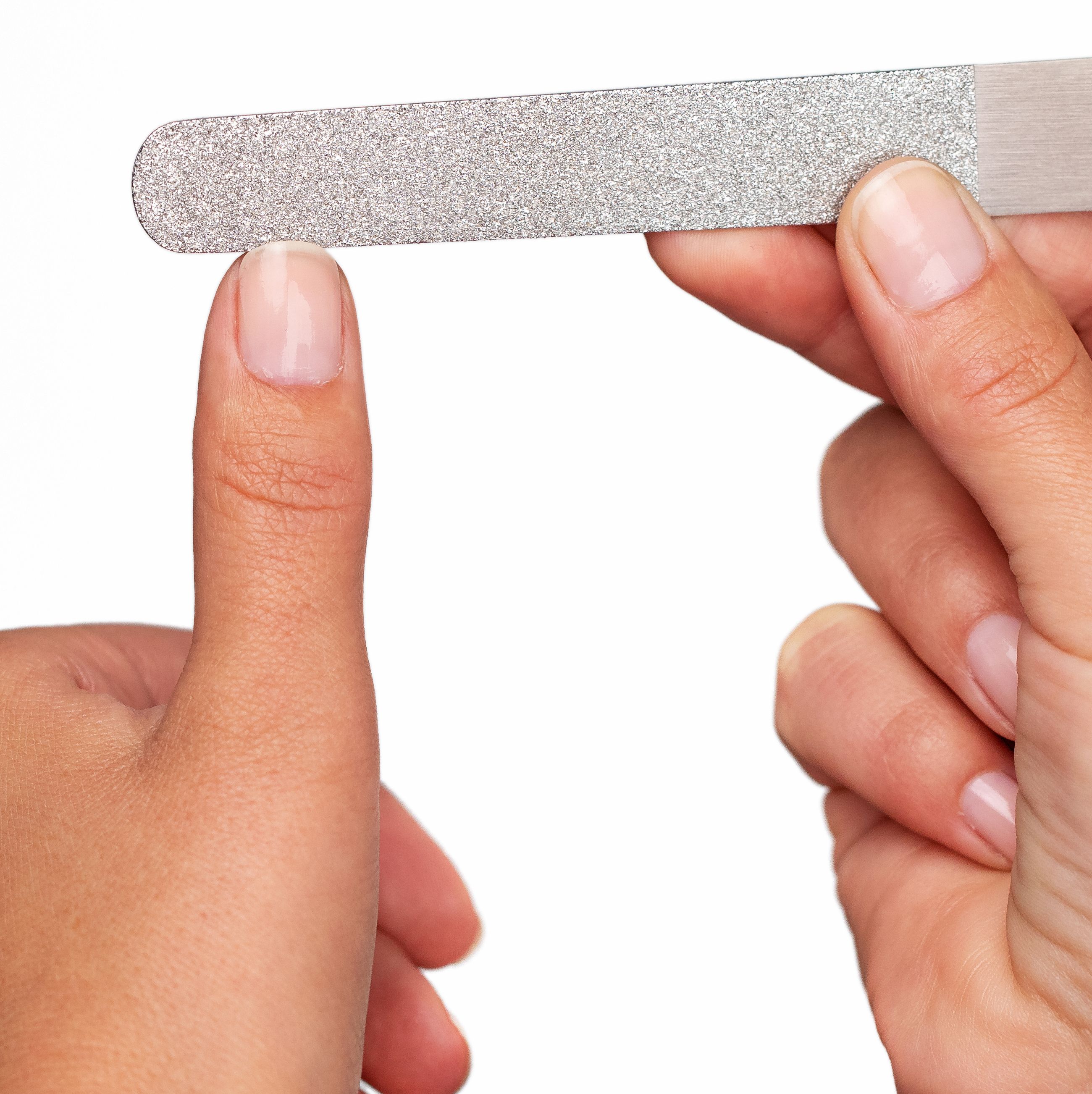 Eine Hand hält eine Diamantnagelfeile an einen Zeigefinger-Nagel zur Maniküre.