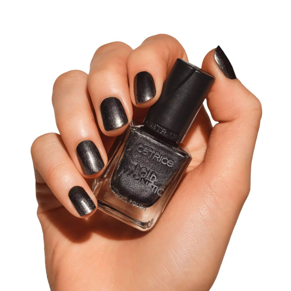 Hand mit lackierten Nägeln und Nagellack-Flakon. Aufschrift: Catrice, Bold Magnetic, Nail Polish. Farbe: Grau.