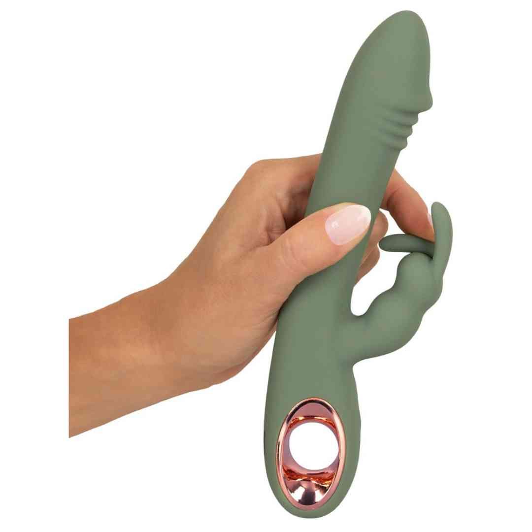 Grüner Vibrator mit Hasenohren, gehalten von einer Hand. Rosegoldfarbener Akzent am unteren Ende.