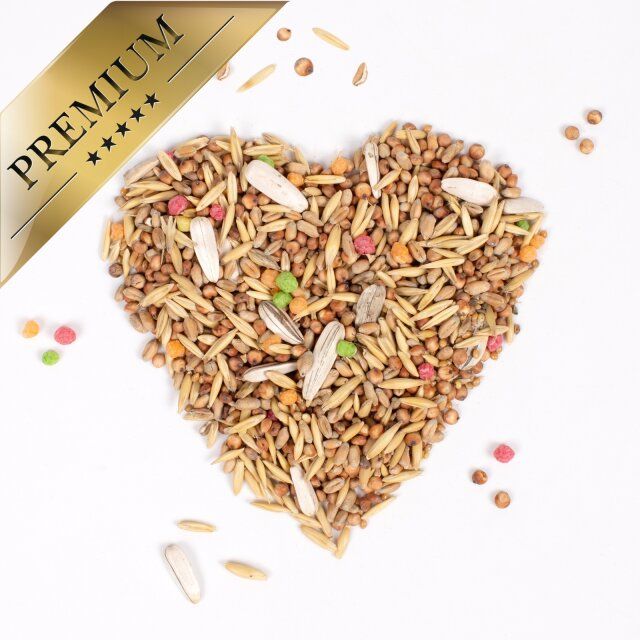 Vogelstreufutter in Herzform. Goldene Plakette: PREMIUM. Streufutter verstreut. 