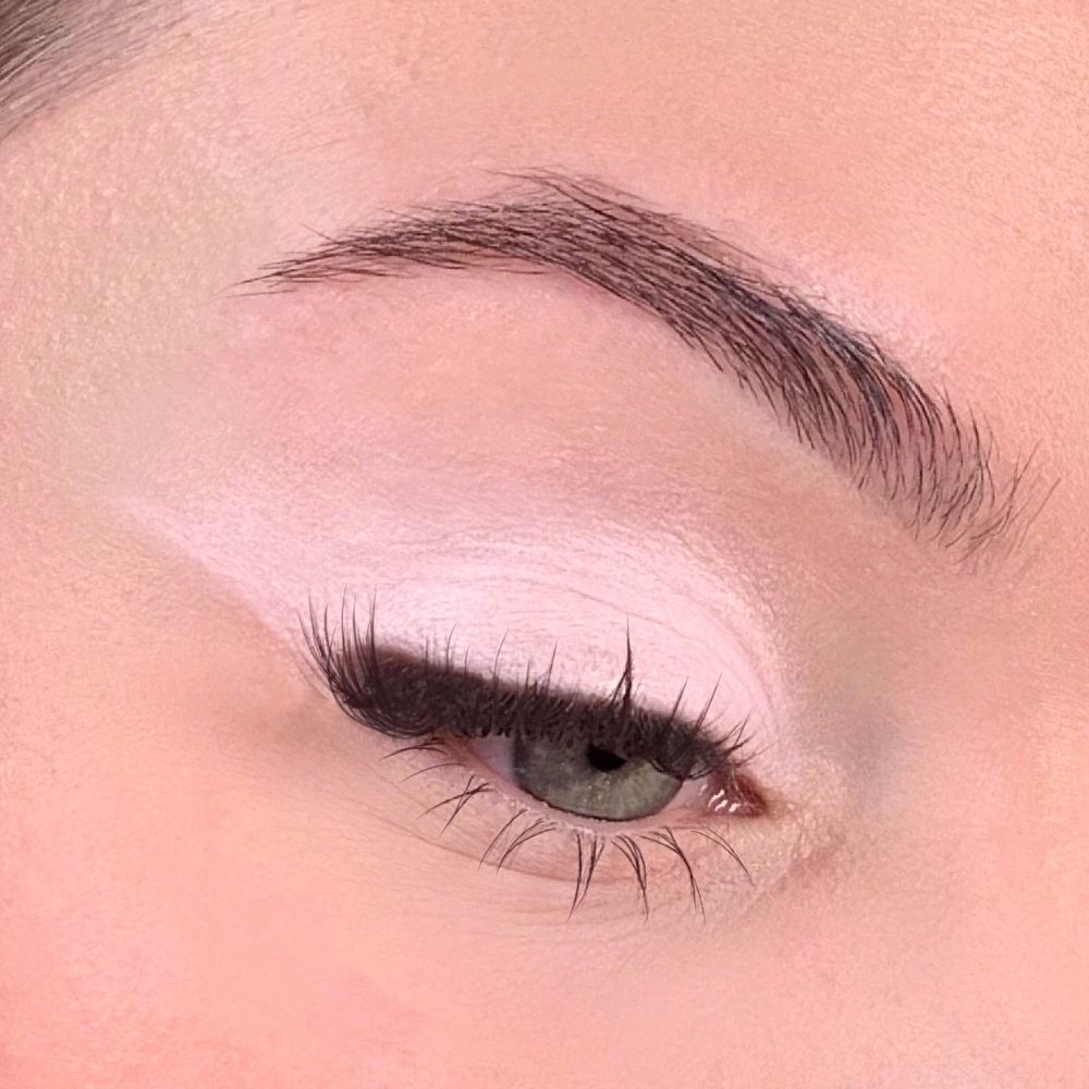 Auge mit rosa Lidschatten. Augenlid mit rosa Lidschatten bedeckt. Braue und Wimpern sichtbar.