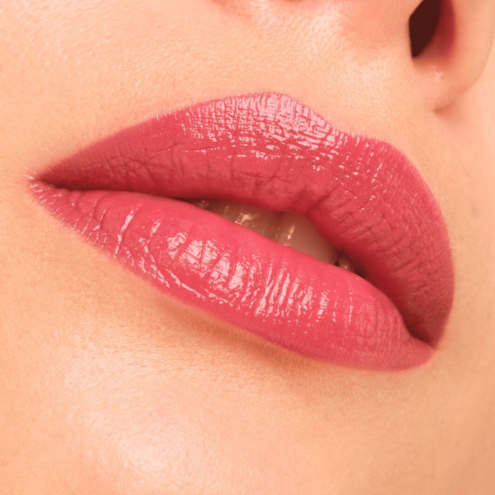 Nahaufnahme von Lippen mit glänzendem, rosafarbenem Lippenstift. Die Lippen sind leicht geöffnet.