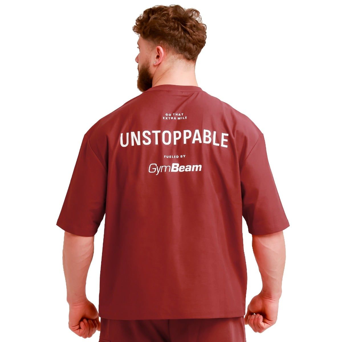 Rückansicht eines roten Oversize T-Shirts für Herren mit dem Aufdruck 'UNSTOPPABLE' und 'GymBeam'.