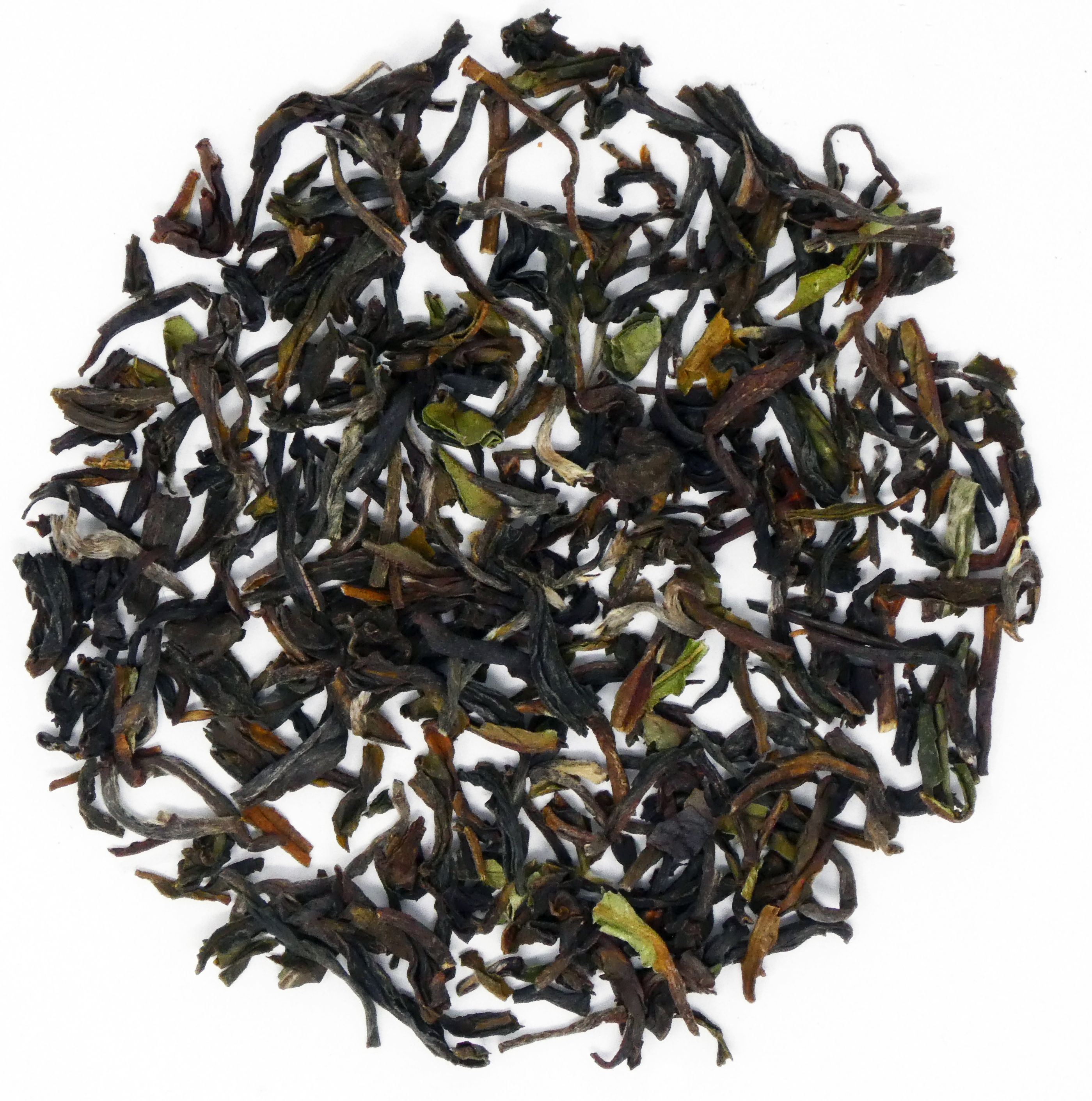 Draufsicht auf lose Darjeeling-Teeblätter. Blätter in verschiedenen Grüntönen und Brauntönen, auf weißem Hintergrund.