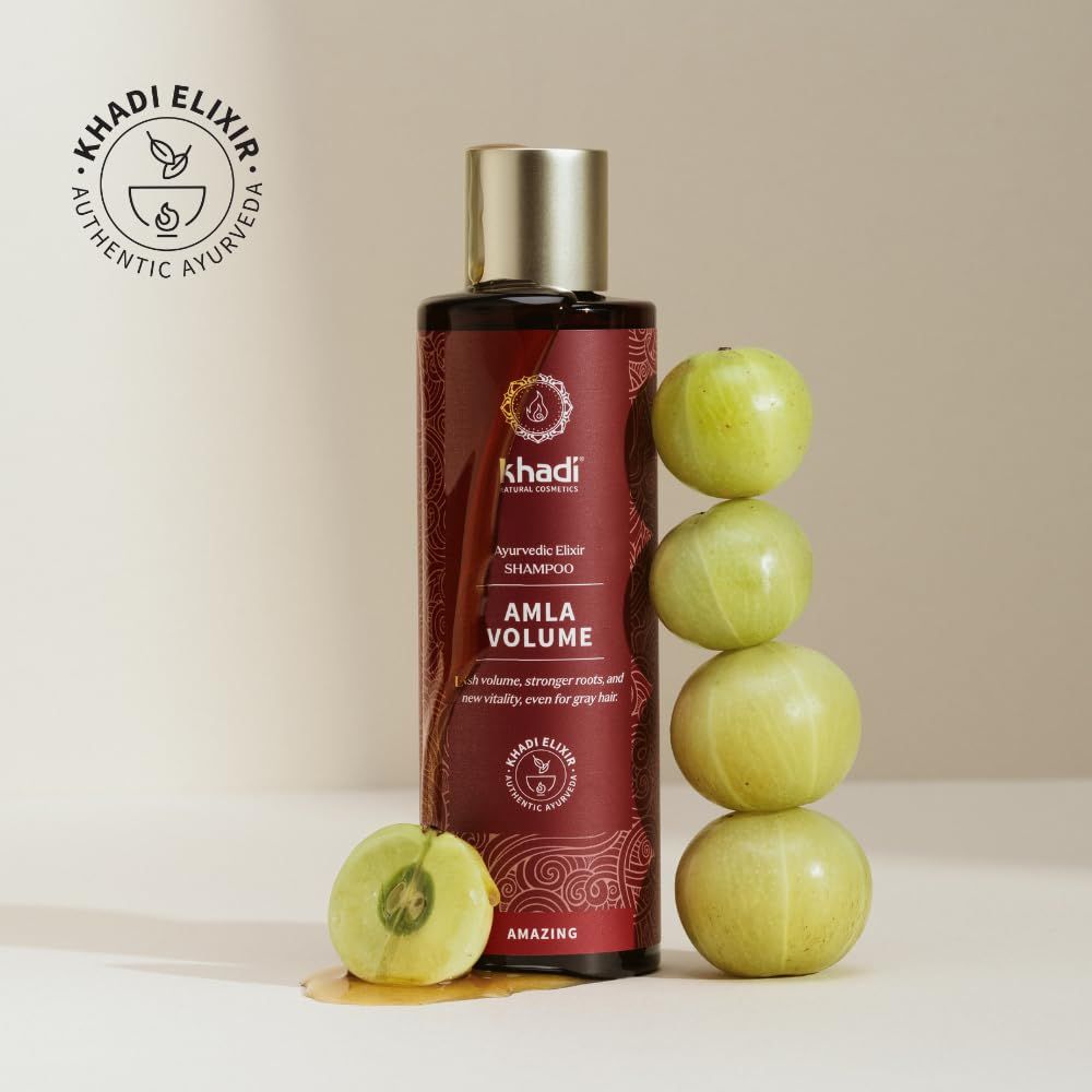 Braune Flasche mit Produktnamen und Logo. Text: Amla Volume. Daneben grüne Früchte. Logo: Khadi Elixir.