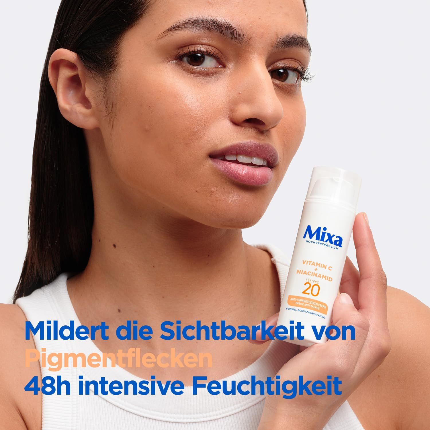 Frau hält Mixa Creme. Mildert Pigmentflecken. 48h intensive Feuchtigkeit. Produkt mit Vitamin C und Niacinamid.