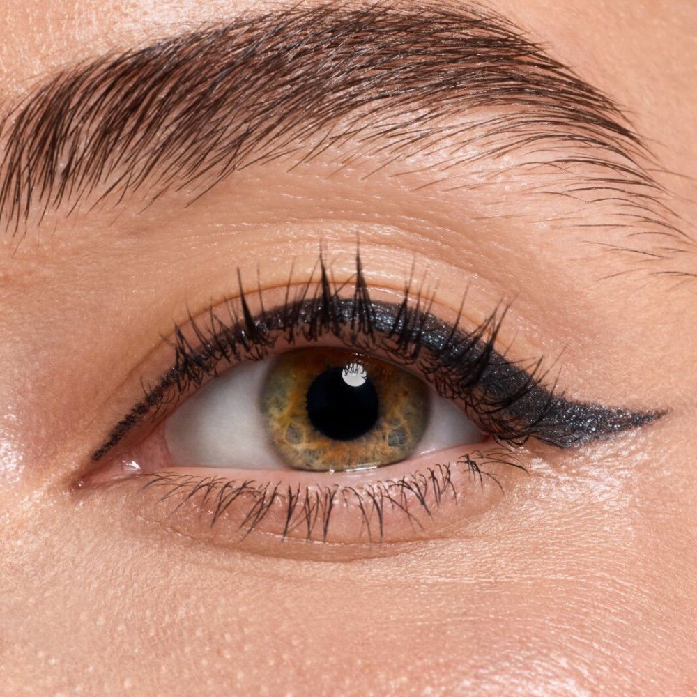 Nahaufnahme eines Auges mit Lidstrich. Wimpern schwarz.