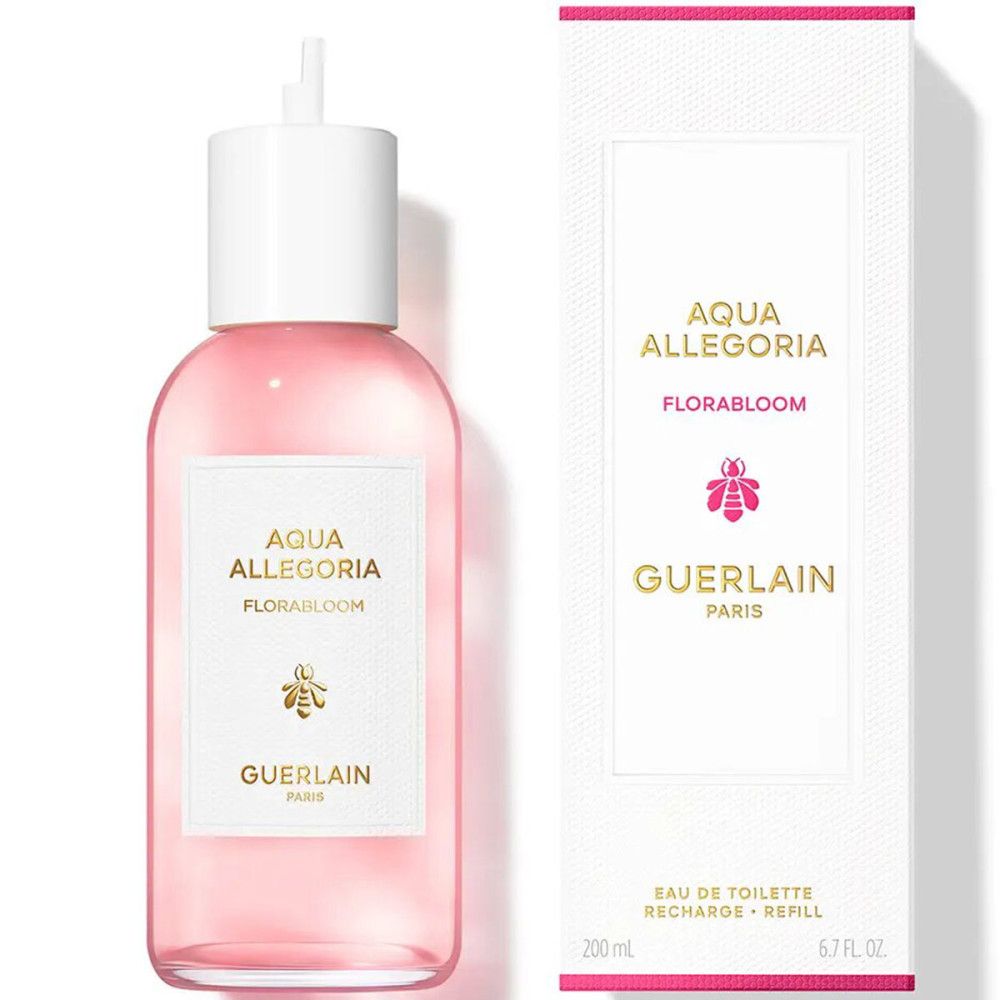 Rosa Flüssigkeit in einer Flasche mit weißem Verschluss. Aufkleber mit Text: Aqua Allegoria Florabloom, Biene, Guerlain Paris. Weiße Verpackung.