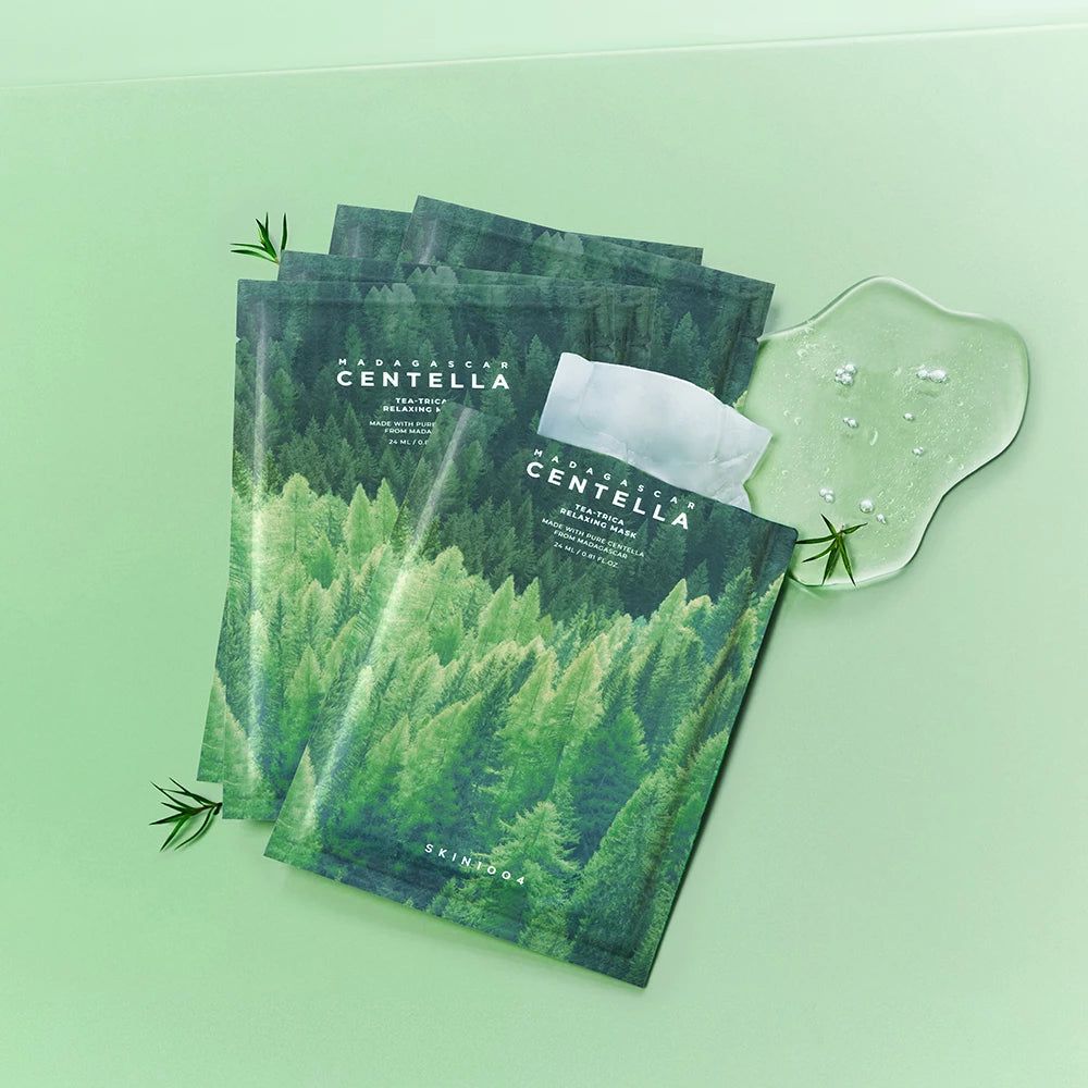 Mehrere Maskenpackungen mit Waldmotiv und Produktnamen. Daneben eine transparente Gelmasse und Blätter. Text: Madagascar Centella.