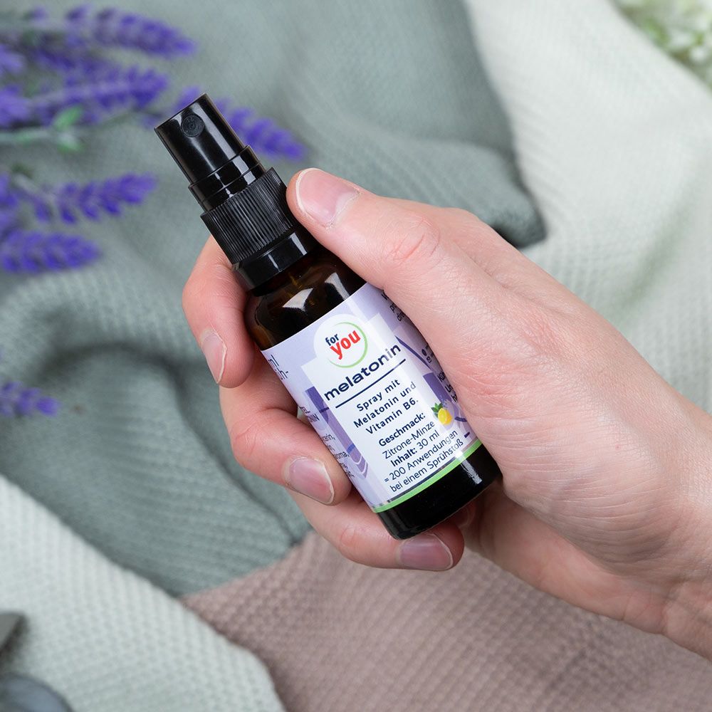 Hand hält eine Flasche Melatonin Spray mit Vitamin B6, Zitronen-Minz-Geschmack.
