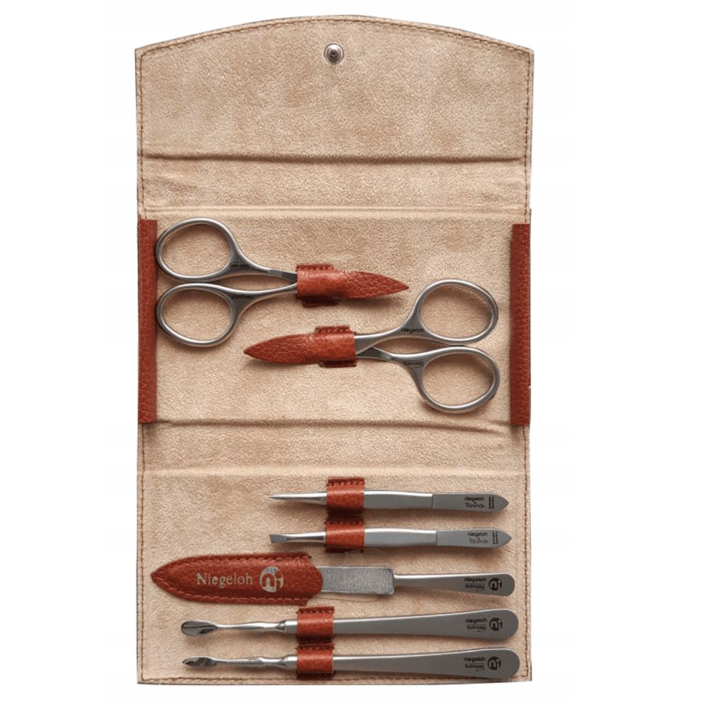 Beiges Etui mit Maniküre-Set. Enthält Scheren, Feilen, Pinzetten und einen Hautschieber. Braune Lederdetails.