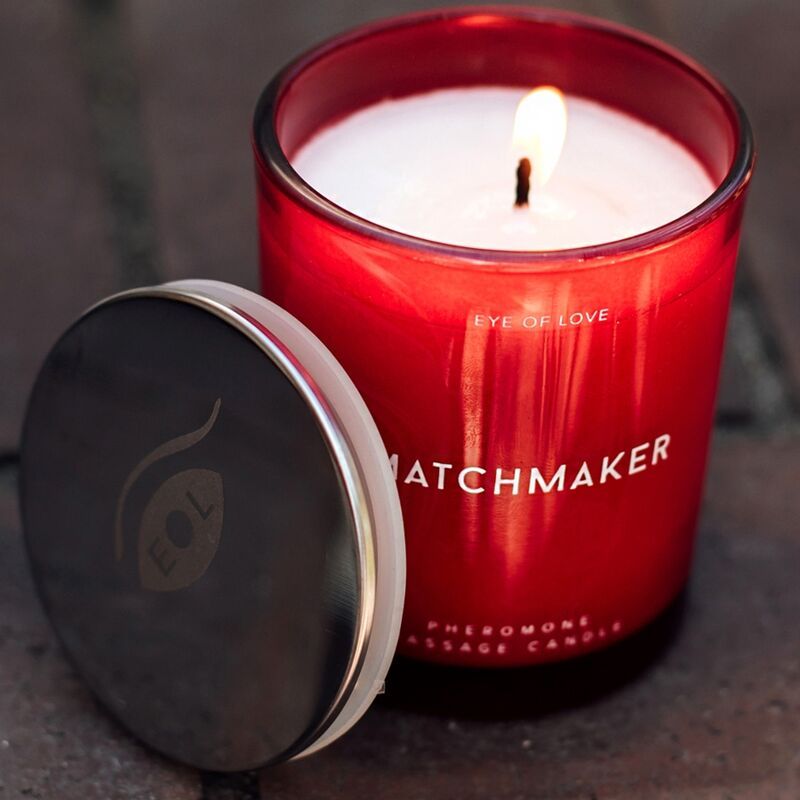 Rote Kerze im Glas mit Deckel. Aufschrift: MATCHMAKER, EYE OF LOVE, Pheromone Massage Candle. Deckel daneben.
