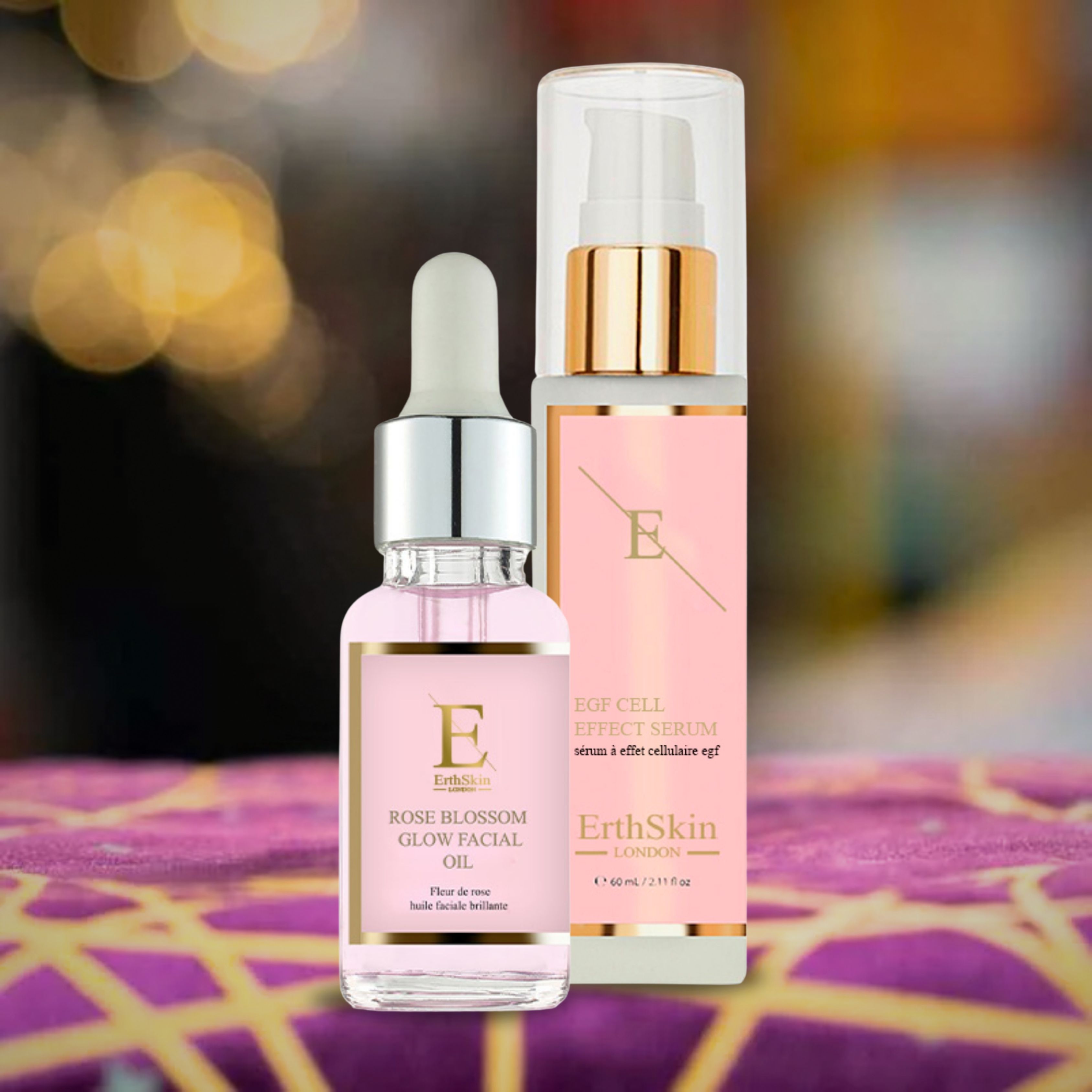 Zwei Flakons: Rose Blossom Glow Facial Oil und EGF CELL EFFECT SERUM. Rosa Flüssigkeit, goldfarbene Akzente, verschwommener Hintergrund.