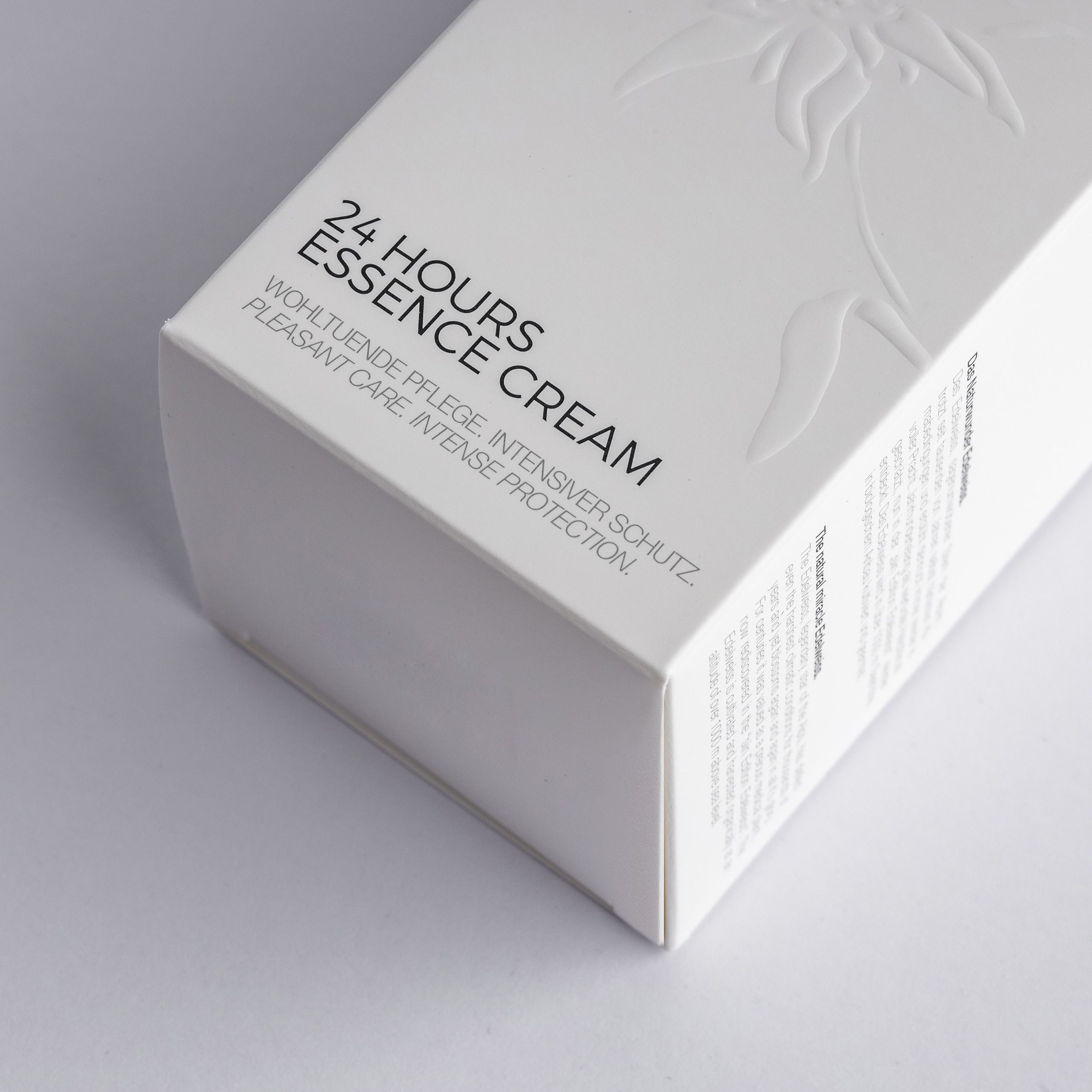 Nahaufnahme einer weißen Produktverpackung mit Text. Aufschrift: 24 HOURS ESSENCE CREAM, siin EDITION EDELWEISS.