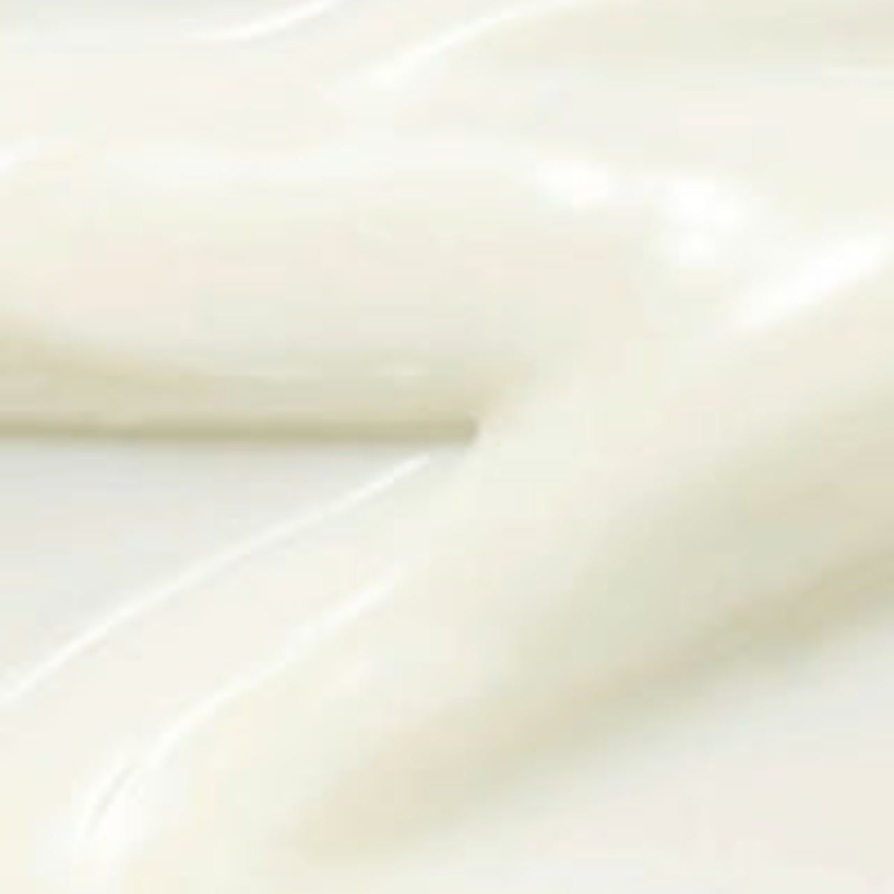 Nahaufnahme einer weißen, glänzenden Creme. Die Textur ist glatt und cremig.