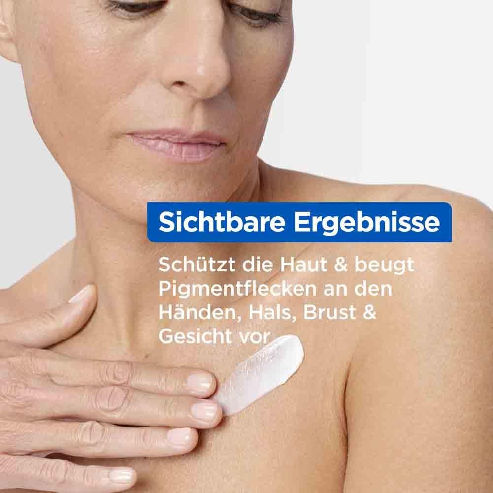 Frau mit Creme auf der Brust. Aufschrift: Sichtbare Ergebnisse. Schützt Haut, beugt Pigmentflecken vor. Produkt im Bildausschnitt.