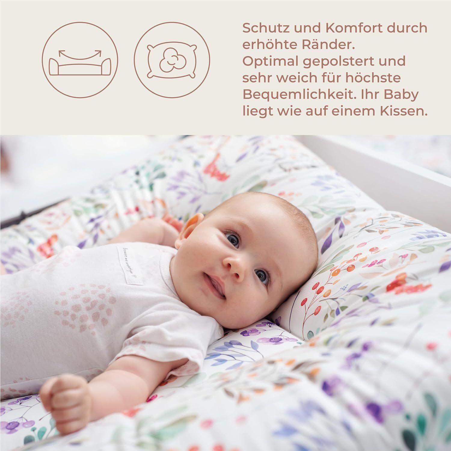 Baby liegt auf einer Wickelauflage mit Blumenmuster. Text: Schutz und Komfort durch erhöhte Ränder.