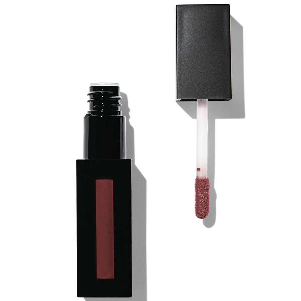 Schwarze Lipgloss-Tube mit geöffnetem Deckel und Applikator. Der Applikator zeigt eine matte, bräunliche Farbe. Der Behälter ist rechteckig.