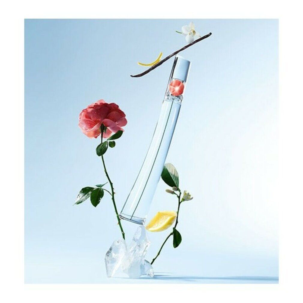 Glasflakon mit roter Blume, umgeben von Blüten, Zitrone und Eis. Auf blauem Hintergrund.