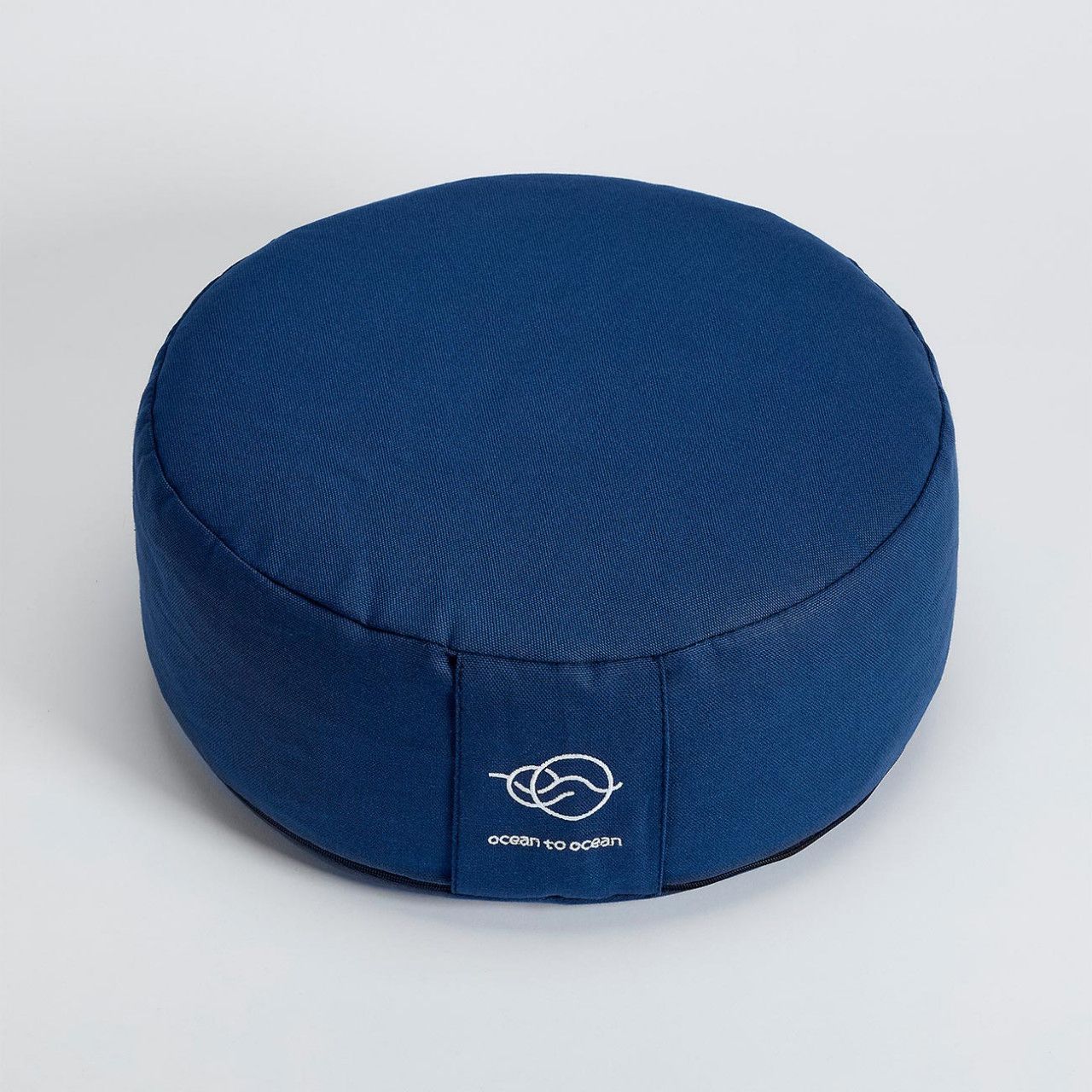 Rundes, blaues Meditationskissen mit Logo. Marke: ocean to ocean. Auf hellem Hintergrund.
