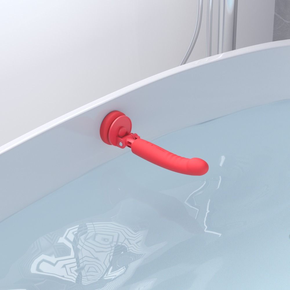 Roter Vibrator mit Saugnapfhalterung in einer Badewanne.