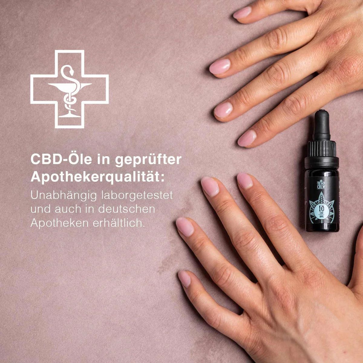 Zwei Hände neben einer kleinen, schwarzen Flasche mit Tropfer. Auf der Flasche ist ein Etikett mit Text und Logo zu sehen.