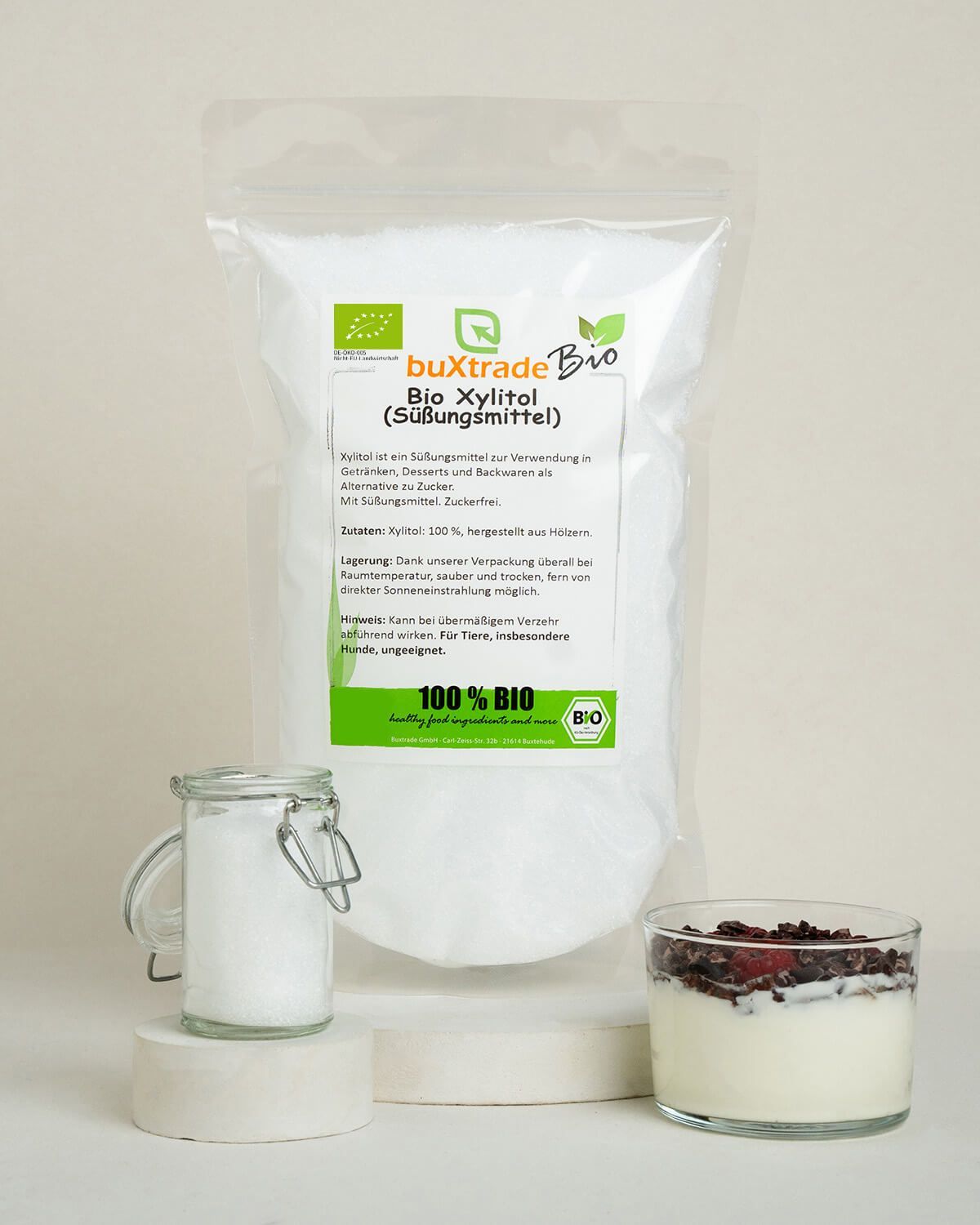 Buxtrade Bio Xylitol Beutel neben einem Glas Xylitol und einem Joghurt.