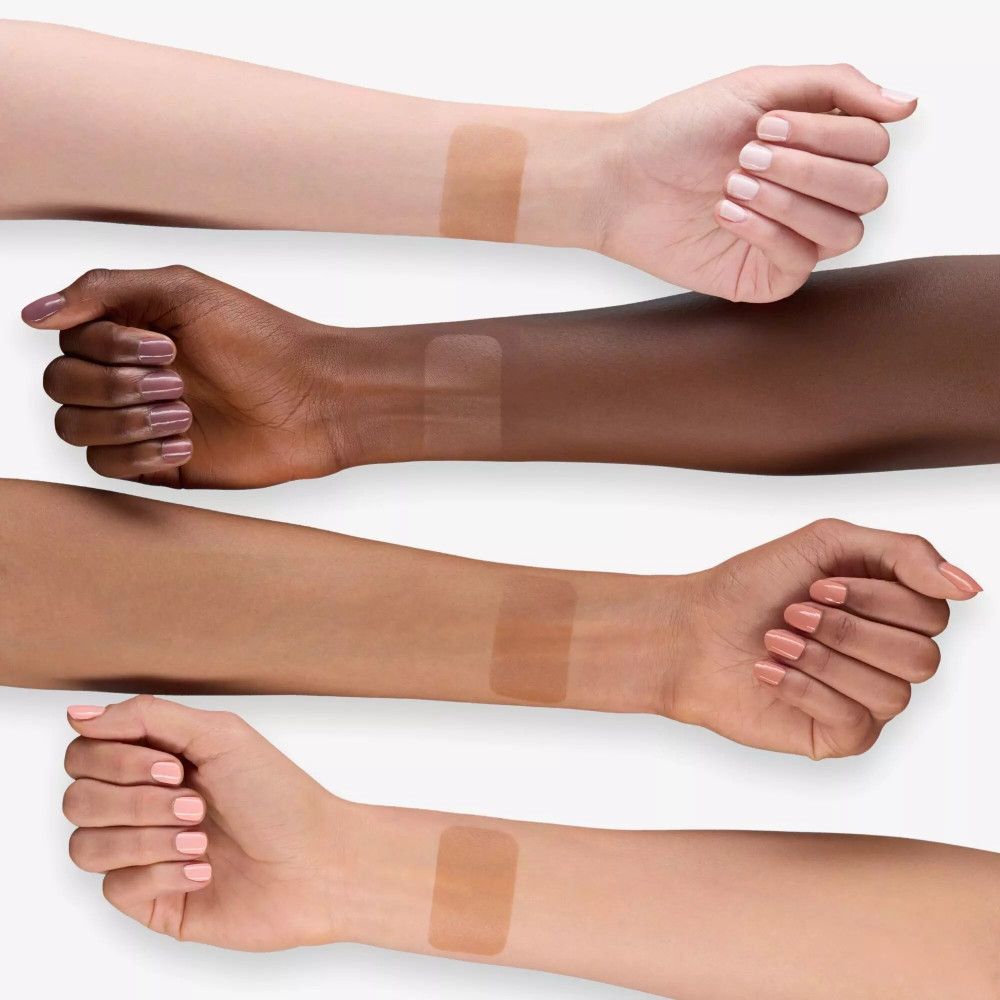 Vier Arme mit Bronzer-Swatches in verschiedenen Hauttönen. Der Bronzer ist in rechteckigen Formen aufgetragen.
