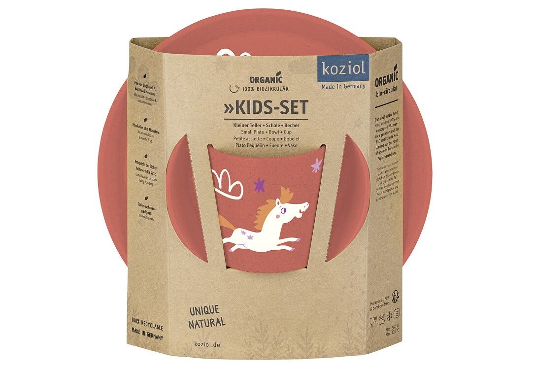 KOZIOL 'Dreams' Kinder-Set in Verpackung. Enthält Teller und Schüssel. Karton mit Produktnamen und Logo.
