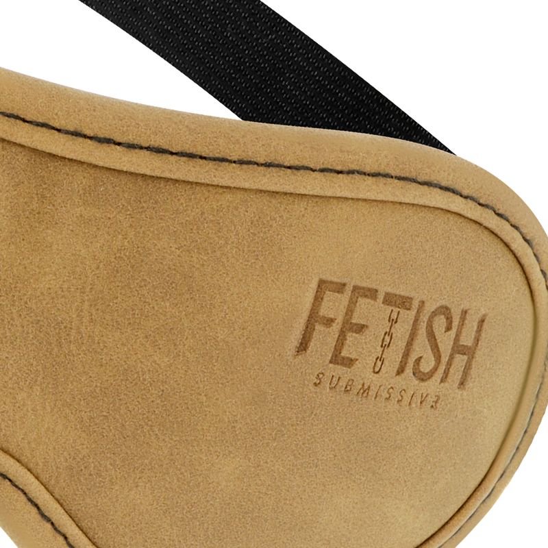 Nahaufnahme einer beigen Augenmaske aus Kunstleder. Auf der Maske steht "FETISH SUBMISSIVE".