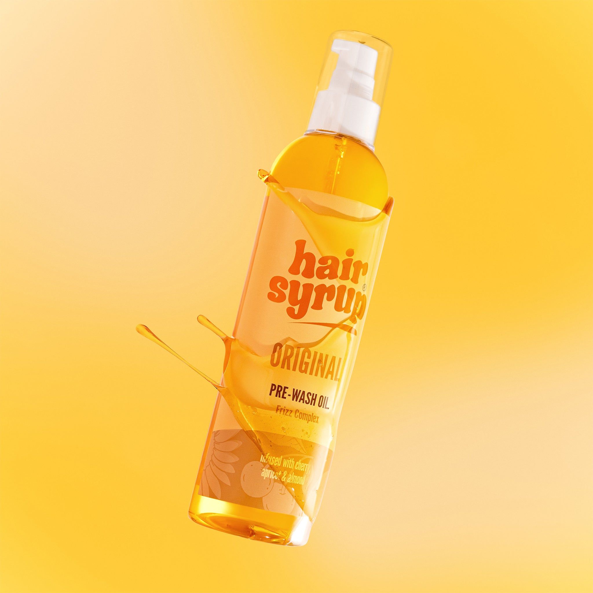 Hair Syrup The Original-Flasche mit Flüssigkeitsspritzern. Gelber Hintergrund.