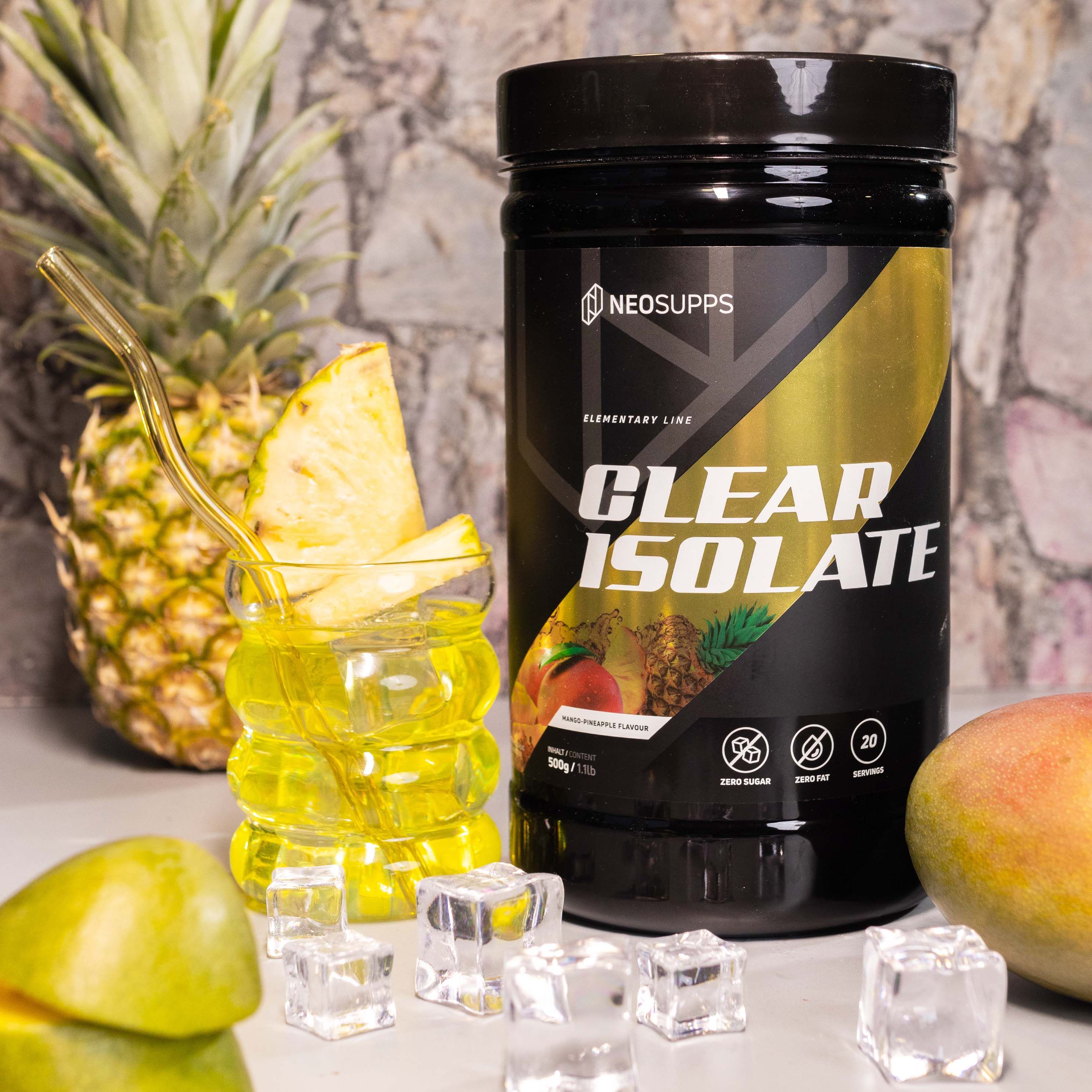 Schwarze Dose "CLEAR ISOLATE" neben Glas mit Getränk, Ananas und Mango. Eiswürfel. Produktverpackung mit Text.